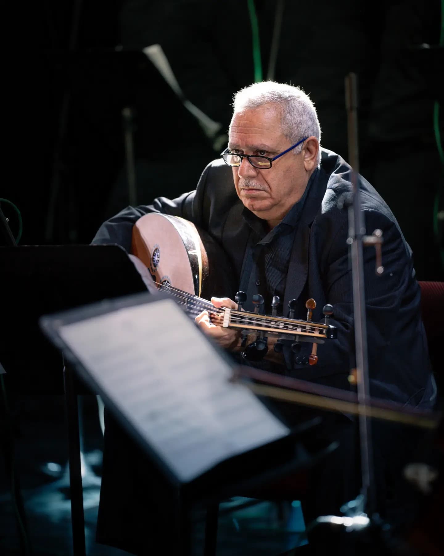 Strings in the Spotlight. Musical performance ignites under light while the body stays central.