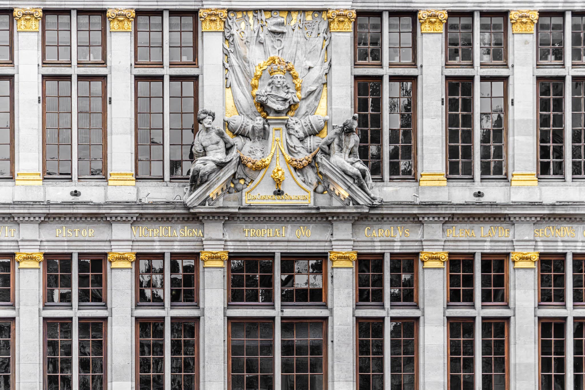 Laurel Crest. An ornamental emblem condensing the facade's identity into a small center.